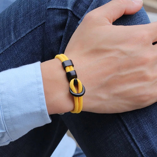 Yellow and black bracelet on a wrist with a blurred background