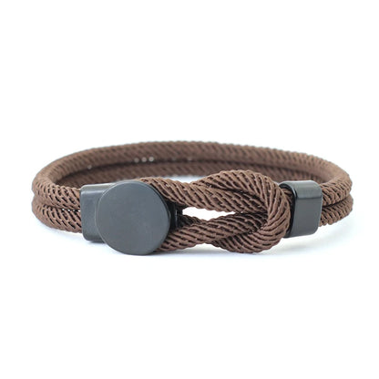 Brown braided bracelet with metal clasp on a white background