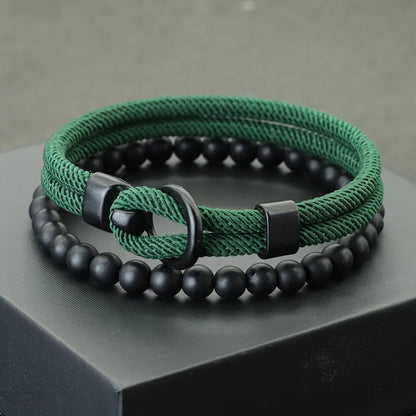 A red and black bracelet with a combination of smooth black beads and a textured red cord, displayed on a gray platform.