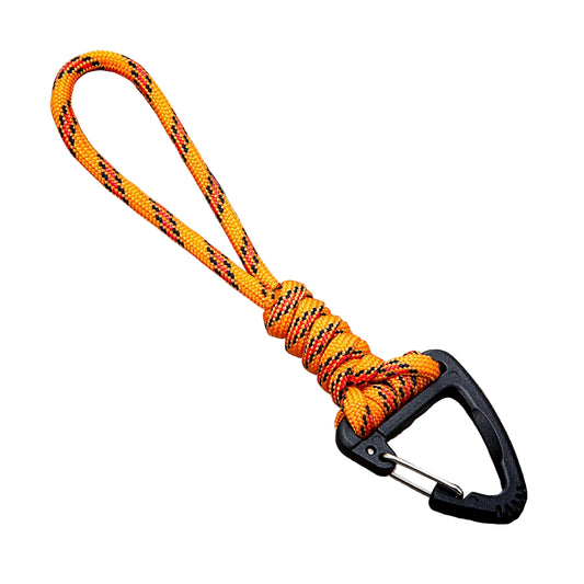 Orange and black braided rope with a carabiner on a concrete surface
